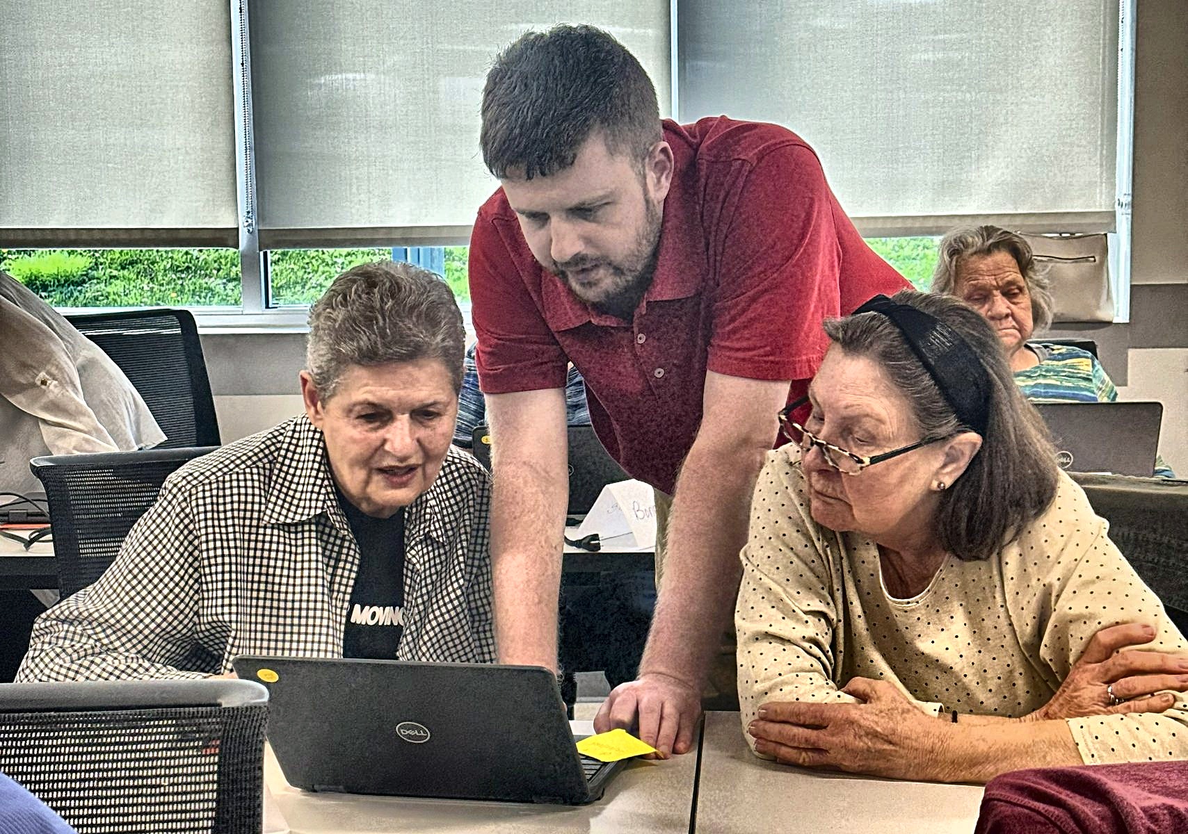 An instructor helping adult learners build technology skills